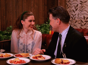 scene from Twin Peaks with Lynch and Amick sitting at a table with plates full of slices of pie